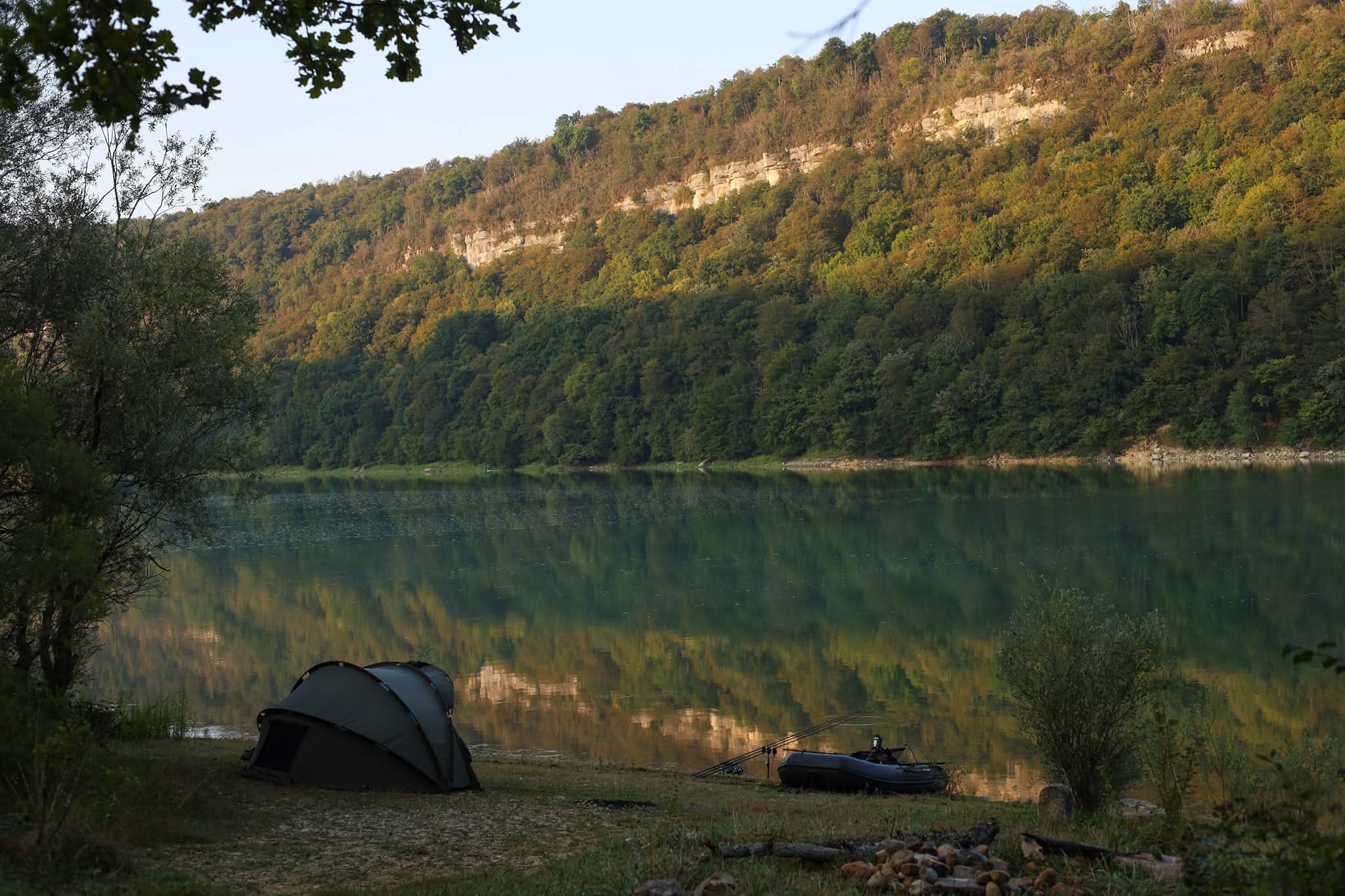 Bivvy tent pitched on the bank of a French public lake at dawn